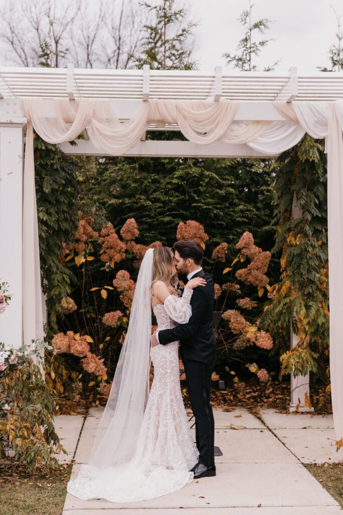 Bride and groom sharing their first kiss as husband and wife at their Bay Pointe Wedding