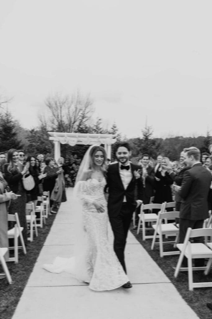 Bride and groom walking down the aisle together for the first time as husband and wife.
