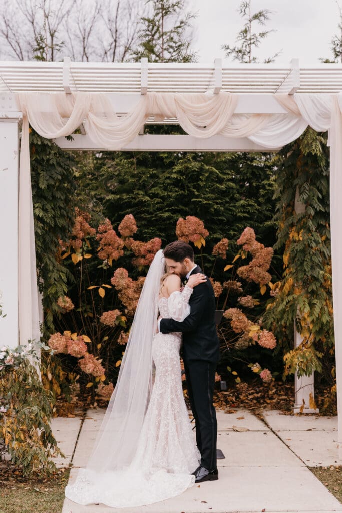 A warm embrace of the bride and groom right after first kiss.